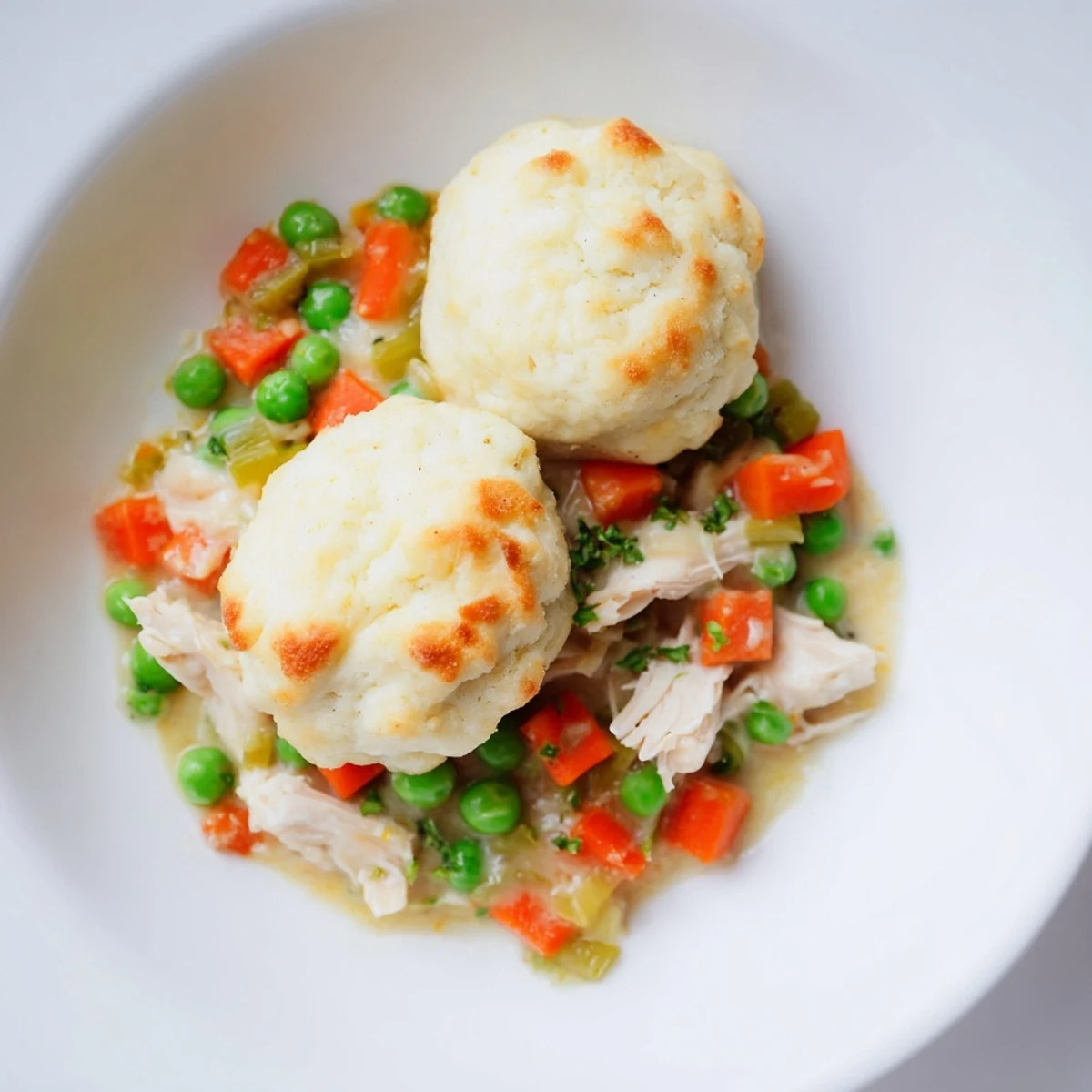 Chicken and Dumplings Casserole, bubbling hot, filled with fluffy dumplings and a creamy, savory sauce.