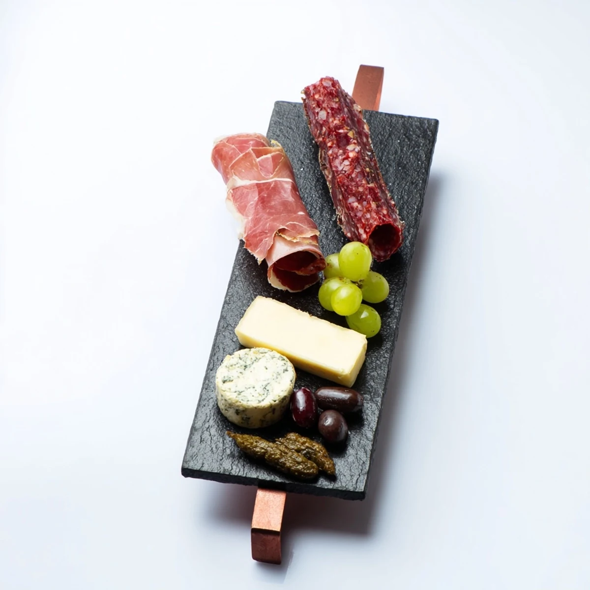 Small Charcuterie Board for One displays an artful arrangement of cheeses and Italian cured meats ready to enjoy.