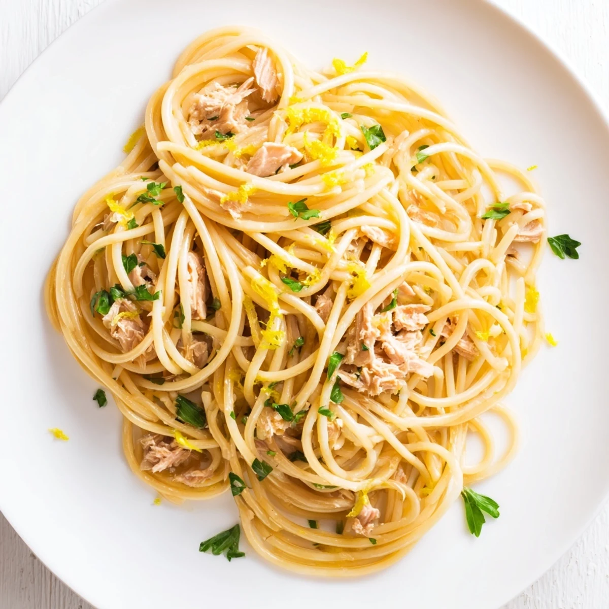 Golden, glistening Lemon-Garlic Tuna Spaghetti with tender pasta, lemon wedges, and fresh parsley.