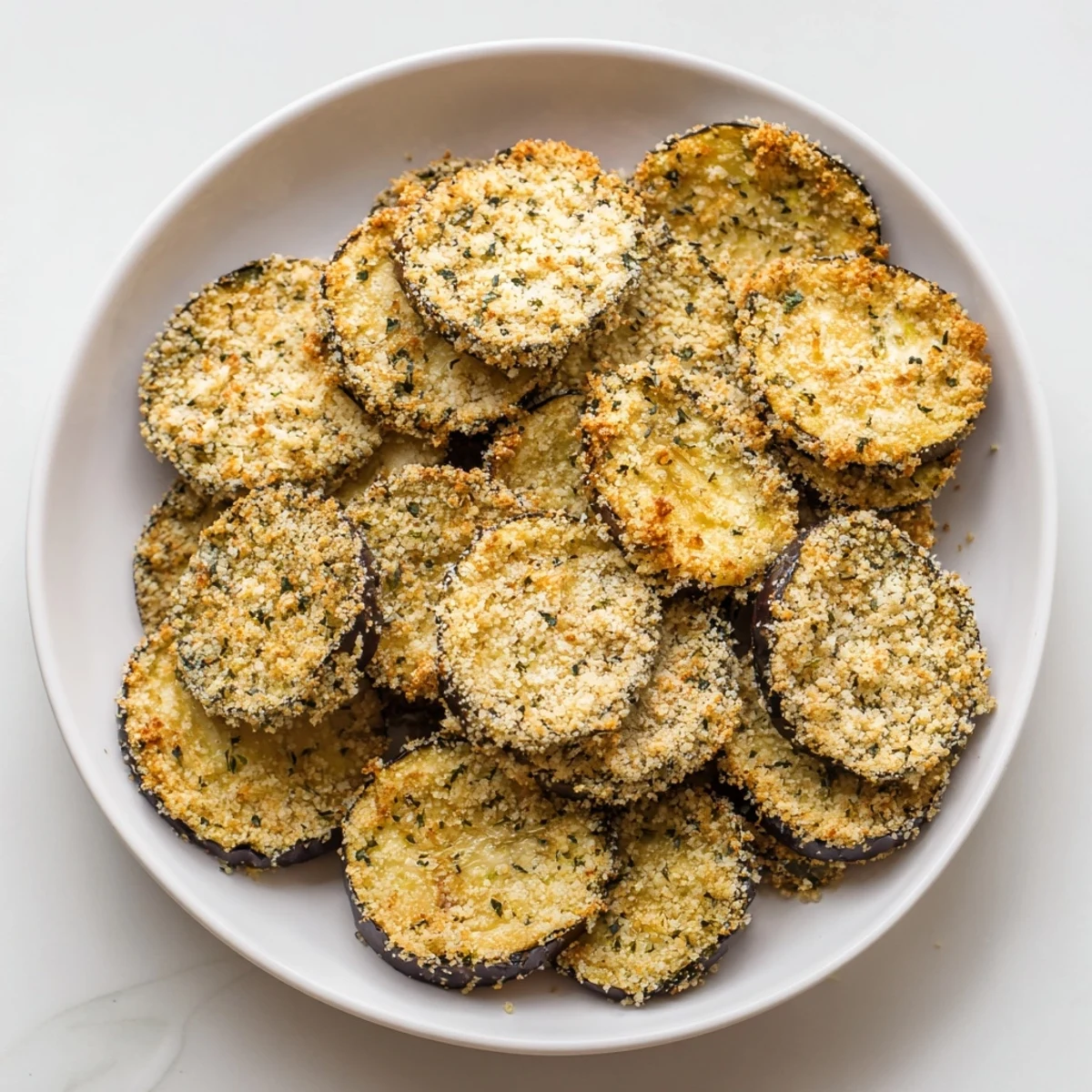 Close-up of baked Crispy Eggplant Parmesan Chips, showing the crispy texture and delicious Italian flavors.