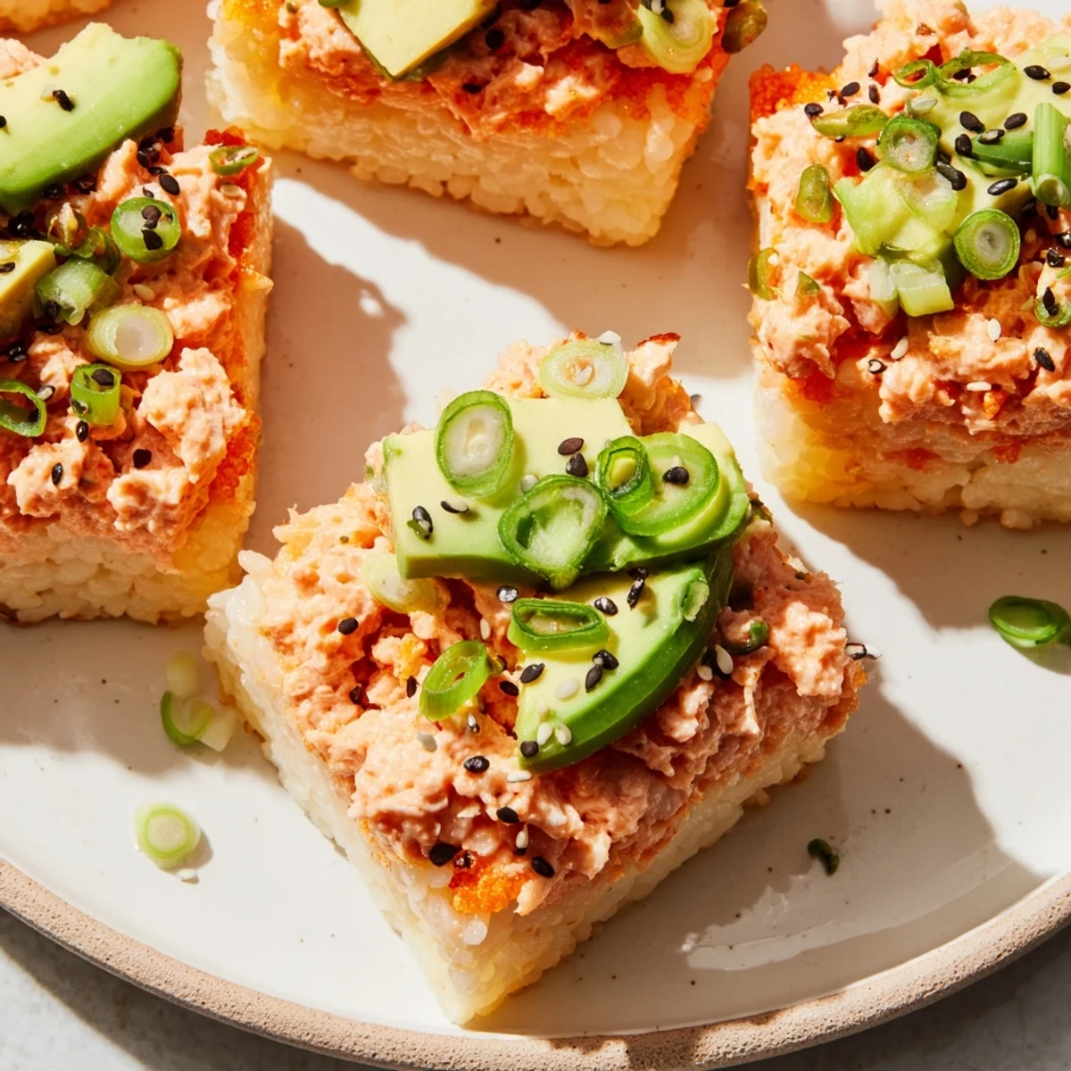Golden, crispy Spicy Tuna Crispy Rice squares topped with a vibrant, spicy fish mixture and creamy avocado.