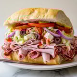 Colorful Flavor Mash-Up Sandwiches drizzled with tangy dressing on toasted rolls.  