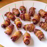Golden brown 3-ingredient bacon-wrapped smokies sizzling on a baking sheet, ideal for game day snacks.
