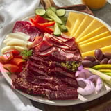 Beautiful Keto Power Plate arrangement: Sliced meats, creamy cheeses, and vibrant vegetables look delicious.