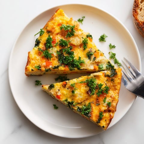 Golden Cheesy Breakfast Biscuit Frittata baked until puffy, showcasing melted cheese and colorful veggies.