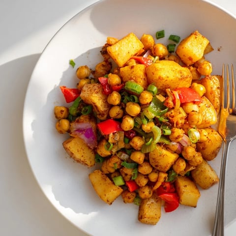 A skillet of Cajun Chickpea Breakfast Hash, seasoned chickpeas and colorful bell peppers.