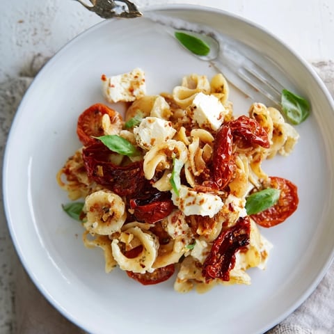 Creamy Baked Feta Pasta served with caramelized onions and fresh basil.  