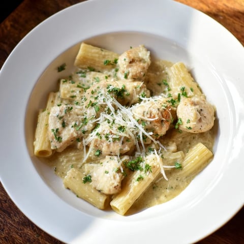 Creamy Garlic Parmesan Chicken Rigatoni with golden chicken pieces and a lush, white sauce, ready to serve.