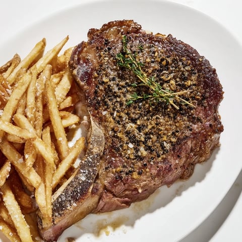Sizzling classic peppercorn ribeye, perfectly seared with golden-brown fries and rich, creamy sauce.