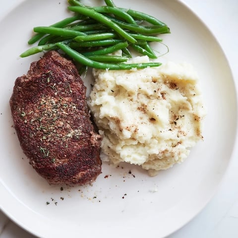 Sizzling sirloin steak and creamy garlic mashed potatoes share a sheet pan for this easy recipe.
