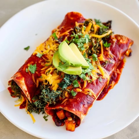 One-Pan Sweet Potato, Black Bean & Kale Enchiladas, baked golden with bubbly cheese and savory sauce.