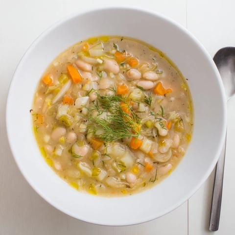 Creamy Simple White Bean and Fennel Soup, garnished with fennel fronds, looks warm and inviting.