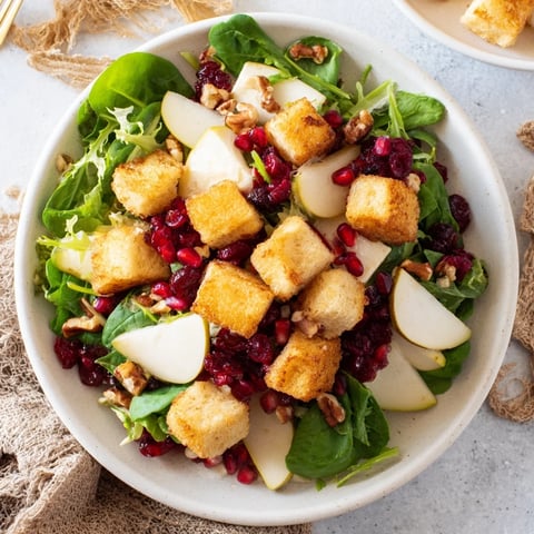 Golden, flaky cranberry and brie flower bites atop fresh salad with pomegranate seeds and pecans.
