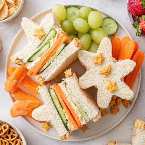 Starfish sandwiches alongside grapes and crackers create a fun Beach Day Starfish snack platter.