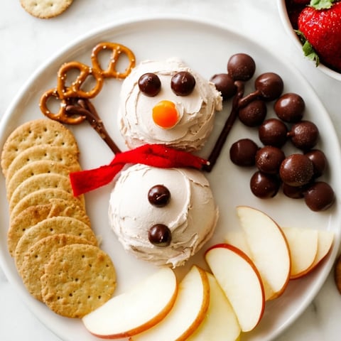 Whimsical snowman made from creamy, rich Hot Cocoa Dip, surrounded by dippers for festive enjoyment.