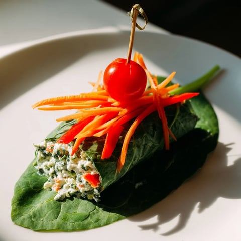 Holly Leaf Spinach Wraps filled with creamy cheese and colorful veggie inside, a festive and fresh snack.