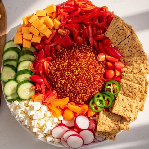 The Spicy Hot Take Platter: a vibrant appetizer featuring chili peppers, cheeses, meats, and crunchy sides.