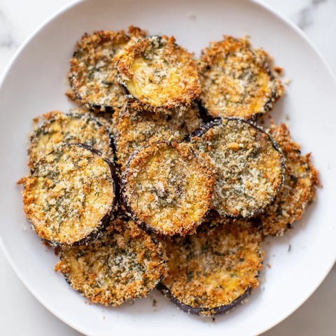 Golden-brown Crispy Eggplant Parmesan Chips fresh from the oven, ready for dipping in marinara sauce.