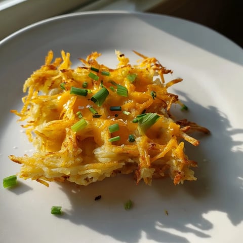 Golden and crispy Cheesy Hash Brown Waffles, ready to serve with sour cream and chives for breakfast.