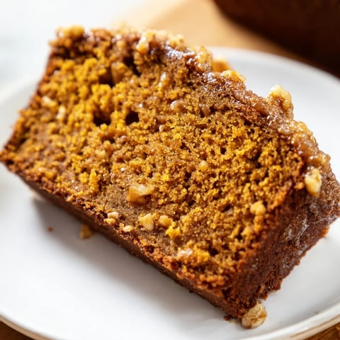 Warm, spiced pumpkin bread loaf, freshly baked and ready to slice for a cozy autumn treat.