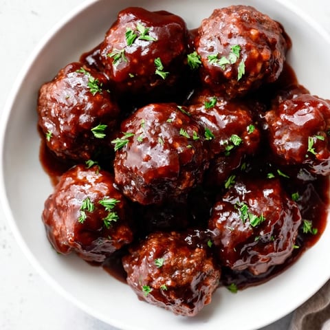 Tempting close-up of slow cooker cherry BBQ meatballs, beautifully coated and ready to serve.