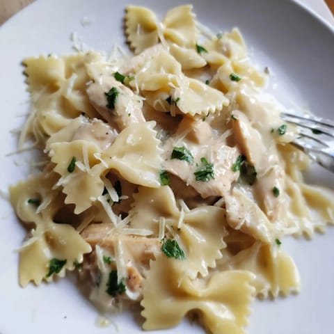Delicious bowtie pasta and tender chicken in creamy garlic butter sauce, ready to serve.  