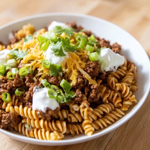 This Cheesy Taco Pasta skillet shows a close-up of cheesy goodness, ready to be served hot.