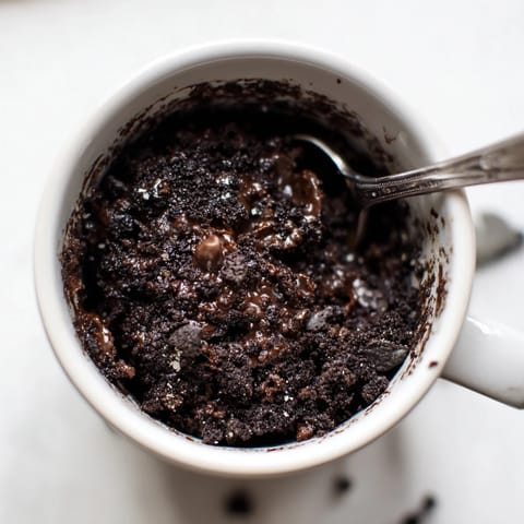 Warm and decadent Oreo mug cake, topped with creamy whipped cream, ready to enjoy.