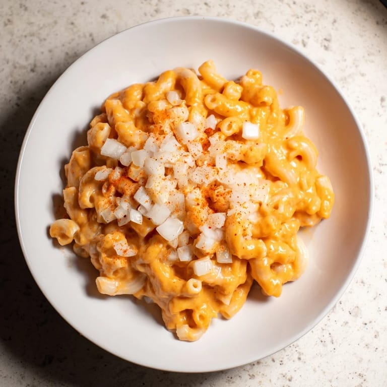 This comforting bowl of One-Pot Butternut Squash Mac & Cheese has a vibrant orange hue, perfect for dinner.