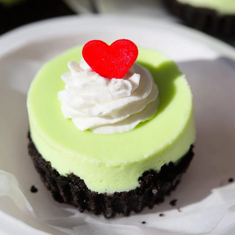 A close-up of creamy, neon green Grinch Mini Cheesecakes ready for your Christmas dessert table.
