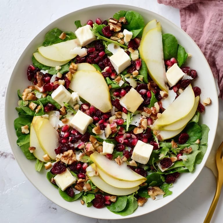 Elegant cranberry and brie flower bites, arranged with a pear salad and a vibrant balsamic dressing.