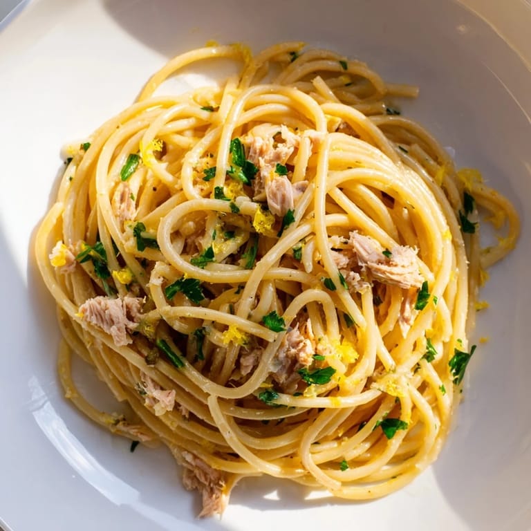 Flaky tuna and zesty lemon dominate this flavorful Lemon-Garlic Tuna Spaghetti, ready in 25 minutes.